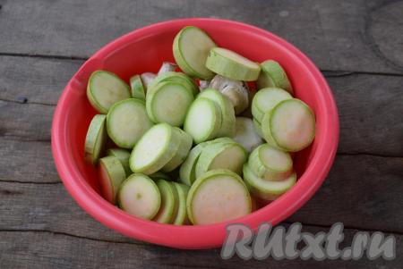 Подготовим грибы, для этого очистим их от верхней пленочки при помощи ножа. Я шампиньоны не мою, а снимаю кожицу, поэтому грибы не впитывают лишнюю влагу и получаются более вкусными. Складываем грибы в миску для маринования. Молодые кабачки нарезаем прямо со шкуркой на кружочки толщиной не менее 0,5-0,7 см. Кабачки также отправляем в миску.