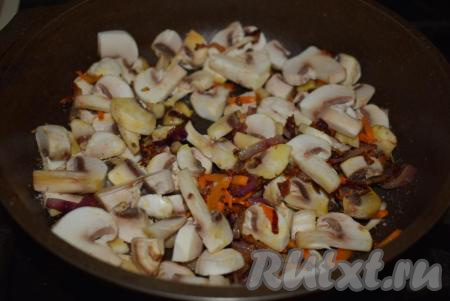 К обжаренным овощам добавляем шампиньоны и жарим на слабом огне, примерно, 10-15 минут, периодически помешивая содержимое сковороды.