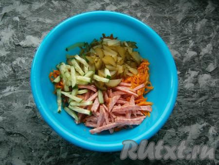 Колбасу, свежий и маринованный огурцы нарезать соломкой. Выложить обжаренные овощи в миску, дать им остыть, добавить к ним огурчики и колбасу.