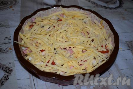 Присыпаем начинку натертым на терке "Российским" сыром. На этом сборка нашей быстрой пиццы закончена.