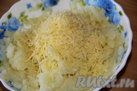 Сыр натереть на мелкой тёрке. Добавить сыр к толчёной картошке и перемешать.