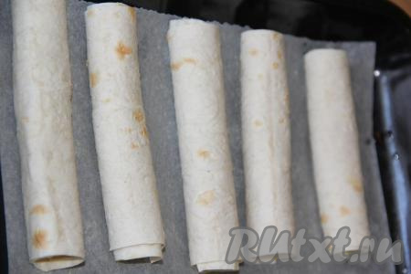 Трубочки из лаваша выложить на противень, застеленный пергаментом.