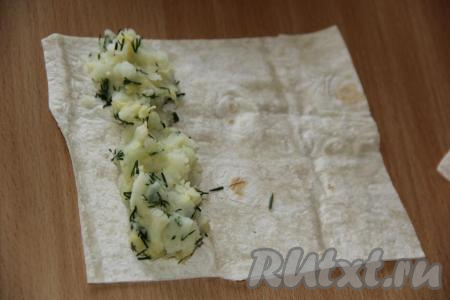 На край лаваша выложить часть начинки (как на фото).
