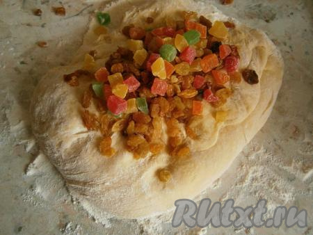 Оставшуюся муку насыпать на стол, выложить тесто и немного его вымесить. Тесто должно быть мягким, нежным, чуть липнущим.&nbsp;Добавить изюм и цукаты, вмешать их в тесто, подсыпая чуть муки, чтобы тесто не липло к рукам и столу.