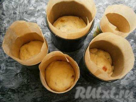 Руки немного смазать растительным маслом и разложить тесто по формочкам на 1/3 их объема. Желательно и дно, и бока форм застелить пергаментом (или использовать специальные бумажные формы для выпечки куличей). Оставить куличи в тепле для расстойки на 30-40 минут. Выпекать куличи в предварительно разогретой духовке при температуре 180 градусов 45-50 минут (готовность можно проверить сухой шпажкой - при прокалывании готовых куличиков шпажка должна остаться сухой).