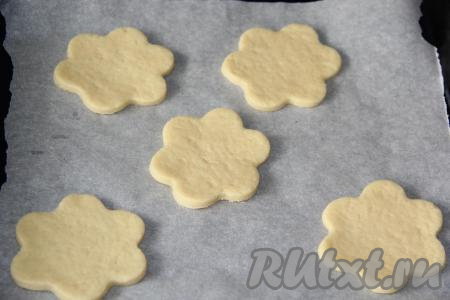 Противень для выпекания застелить пергаментом. Выложить молочные коржики на противень.