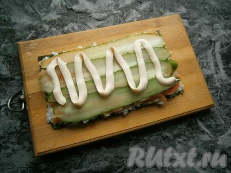 Смазать огурцы немного плавленным сыром.