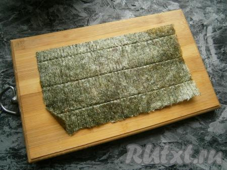Лист нори выложить на досочку (или прямоугольное блюдо) шершавой стороной кверху.