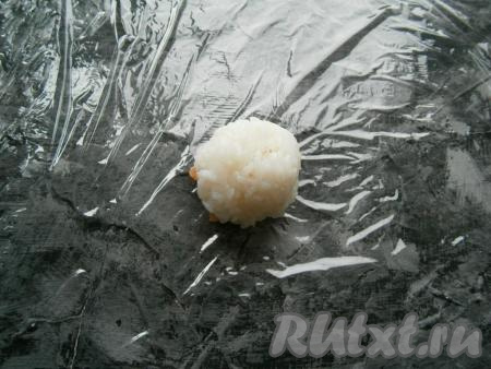 Мокрыми руками скатать из риса шарик весом около 40-50 грамм, разместить его на кусочке рыбы.