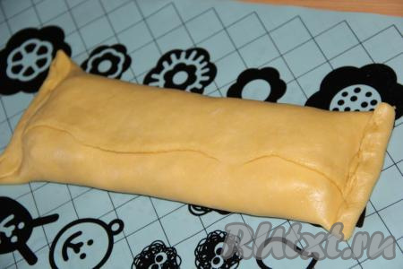 Края теста завернуть с двух сторон, накрывая творожную начинку. Немного подвернуть оставшиеся края теста и хорошо скрепить (как на фото). Аналогично из теста сформировать вторую заготовку с творожной начинкой.