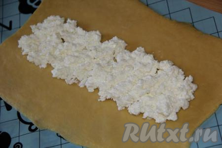 На середину одного пласта выложить&nbsp;часть творога в виде полоски (как на фото).