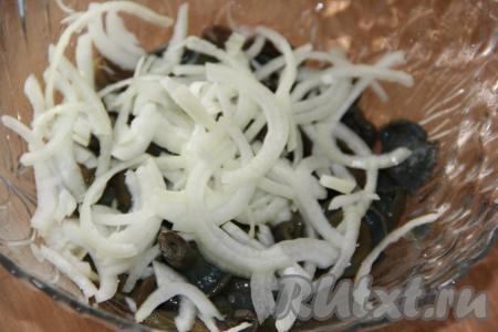 Выложить солёные грибы в миску (если грибы крупные, то можно их разрезать, но не мельчите). Очищенный лук нарезать тонкими полукольцами и добавить к грибам.