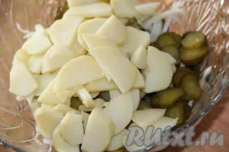 Картофель, предварительно сваренный в кожуре, очистить, нарезать крупными дольками и выложить в салат.