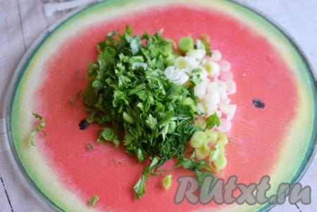 Даём кабачкам немного остыть. Пока кабачки охлаждаются, приготовим ароматный ореховый соус, для этого нарежем мелко зелень, зелёный лук и смешаем с чесноком, пропущенным через пресс.