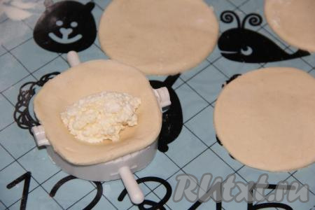 На середину каждого кружка выложить творожную начинку. Я делала крупные вареники и на каждый кружок выкладывала по 1 столовой ложке начинки.