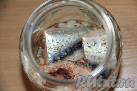 На дно банки поместить немного лука и моркови, затем выложить пару кусочков скумбрии, посолить, добавить специи для рыбы.