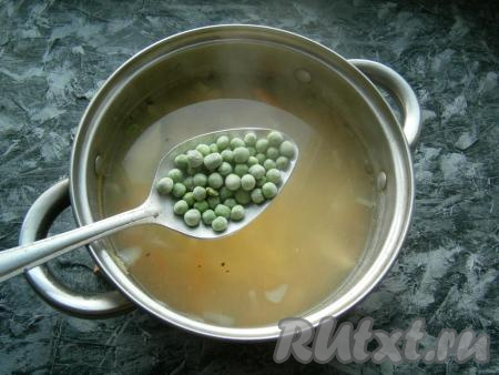 В куриный суп выложить замороженный зеленый горошек, дать закипеть.