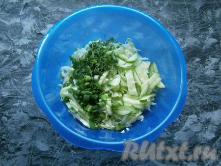 К нашинкованной капусте добавить нарезанный тонкими полукружочками (или брусочками) свежий огурец, измельченную зелень лука и укропа.