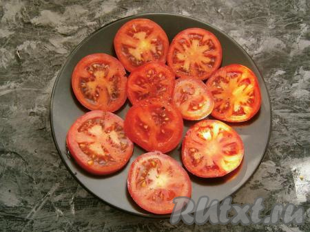 Помидоры нарезать на кружочки&nbsp;толщиной около 0,5 см, разложить их в один ряд на плоскую тарелку, чуточку посолить и поперчить.