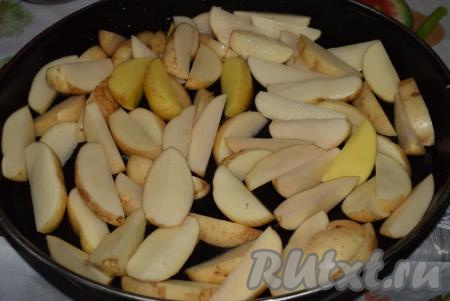 Выкладываем картофельные дольки на противень для запекания.