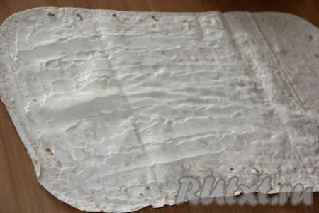 Лист лаваша смазать плавленным сыром. Края лаваша по периметру лучше оставить чистыми.