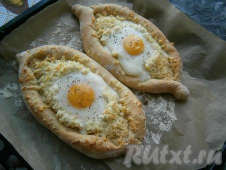 Поместить противень с хачапури по-аджарски в духовку еще на 10-15 минут. Белок яйца должен свернуться, а желток - остаться сырым. Посыпать хачапури сверху чёрным свежемолотым перцем.