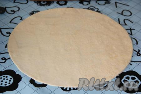 По прошествии 1-1,5 часов дрожжевое тесто хорошо поднимется, его нужно обмять и разделить на две части (в итоге у нас получатся две пиццы с морепродуктами). Оставить тесто на столе под полотенцем на 15 минут. Затем одну часть теста раскатать в тонкий круг. Я раскатала тонко тесто, а затем вырезала ножом&nbsp;ровный круг, используя&nbsp;тарелку.