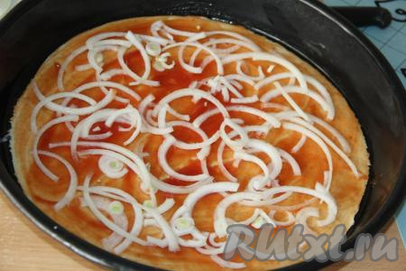 Лук очистить, нарезать тонкими полукольцами. Выложить лук на тесто.