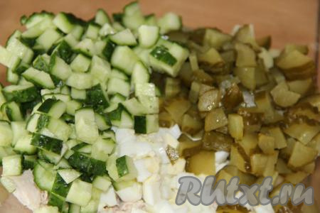 Маринованные огурцы и свежий огурчик нарезать на мелкие кубики и добавить к нарезанным ингредиентам.