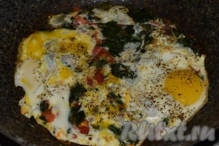 Затем к обжаренным помидорам и шпинату вбиваем яйца, слегка солим и перчим. Готовим яичницу на небольшом огне 2-3 минуты (белок должен полностью свернуться, а желток - остаться жидким).