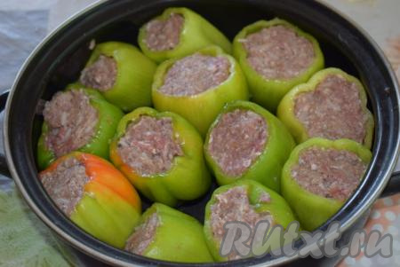 В плоскую широкую кастрюлю выкладываем подготовленные фаршированные перцы.