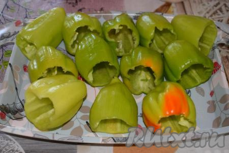 Далее займемся болгарскими перцами. У каждого перчика удалим плодоножку, срезая ножом шапочку, а затем очистим от семян.