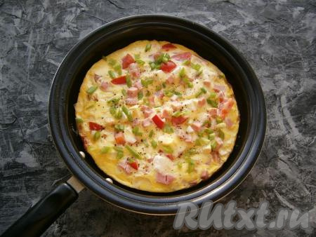 Готовый омлет поперчить сверху и посыпать измельченной зеленью.