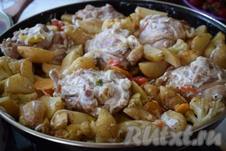 Далее достаем наш противень, переворачиваем бёдра на другую сторону, овощи перемешиваем при помощи ложки, поливая&nbsp;их образовавшимся соком. Сверху смазываем курицу&nbsp;и овощи майонезом.