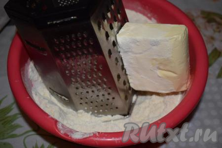 В получившуюся смесь натрём на крупной терке холодное сливочное масло, окуная брусок масла в муку, чтобы оно не скользило.