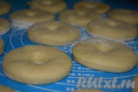 Даём пончикам слегка подойти (в течение минут 15), оставив их на столе и накрыв полотенцем.