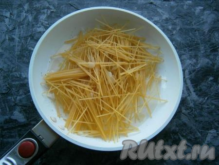 Лук обжарить, иногда помешивая, до мягкости и легкой золотистости. В сковороду выложить спагетти, немного перемешать их с луком.