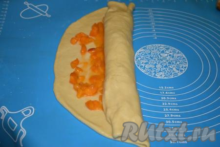 Аккуратно скручиваем тесто с абрикосовой начинкой в рулет. Края рулета плотно защипываем.