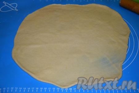 На припылённом мукой столе (или на силиконовом коврике) раскатываем одну часть теста в пласт диаметром, примерно, 50 см и толщиной около 3-4 мм.