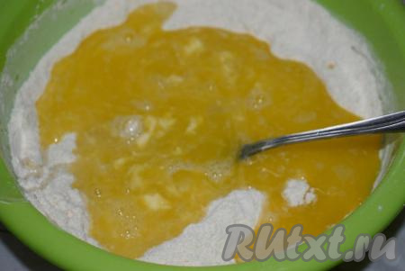 Далее вливаем тёплую воду (температура воды должна быть, примерно, 40 градусов) и начинаем замешивать тесто. Как только тесто свернётся в шар, добавляем растительное масло и продолжаем замешивать тесто.