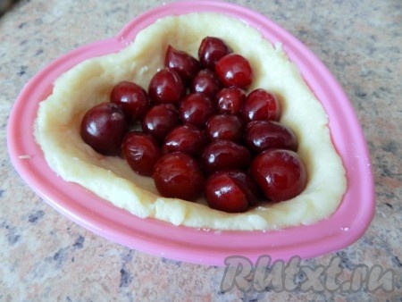 На тесто выложить вишню, очищенную от косточек.