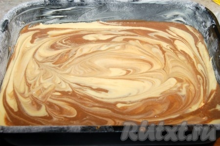 Вылить тесто в подготовленную форму, чередуя обычное тесто с шоколадным. Сверху сделать разводы с помощью острого предмета (поводить кругами). Отправить мраморный пирог в заранее нагретую до 180 градусов духовку. Выпекать от 40 до 50 минут.
