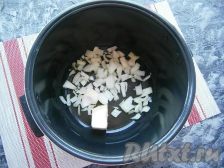 В чашу мультиварки поместить половину сливочного масла, а также очищенный и нарезанный средними кусочками репчатый лук.