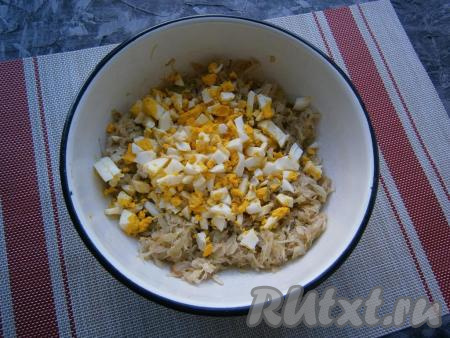 Влить воду и тушить капусту на слабом огне, периодически перемешивая, минут 20. Готовую тушёную капусту выложить в миску и дать ей остыть. К остывшей капусте добавить мелко рубленные варёные яйца.