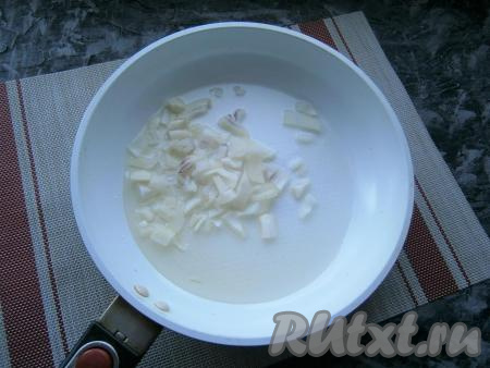 Пока тесто "подходит", нужно приготовить начинку. Для этого в сковороду влить растительное масло, выложить мелко нарезанный очищенный репчатый лук.