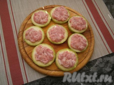 Кольца кабачков немного посолить и заполнить отверстия фаршем.