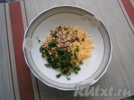 В отдельной тарелке соединить натёртый на мелкой тёрке сыр, мелко нарезанную петрушку и измельчённые орехи.