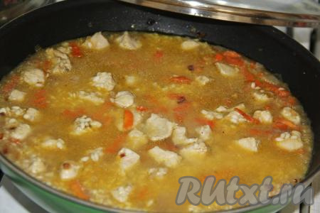 Влить в сковороду крутой кипяток так, чтобы вода была выше уровня риса, примерно, на 2 см.