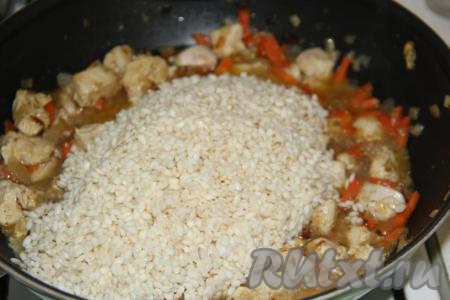 В рис впитается вся вода. Выложить рис в сковороду к овощам, обжаренным с куриной грудкой, перемешать.