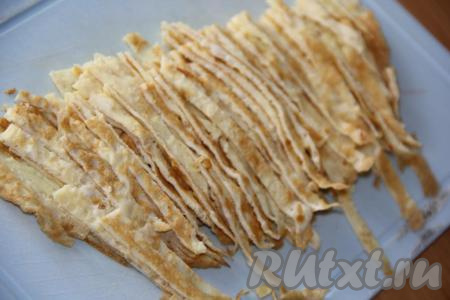 Нарезать охлаждённые яичные блинчики на полоски шириной 0,5 см.